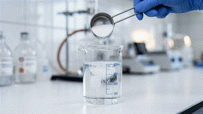 Lab demonstration showing detergent failing to dissolve fully in water, residue settling on fabric fibers